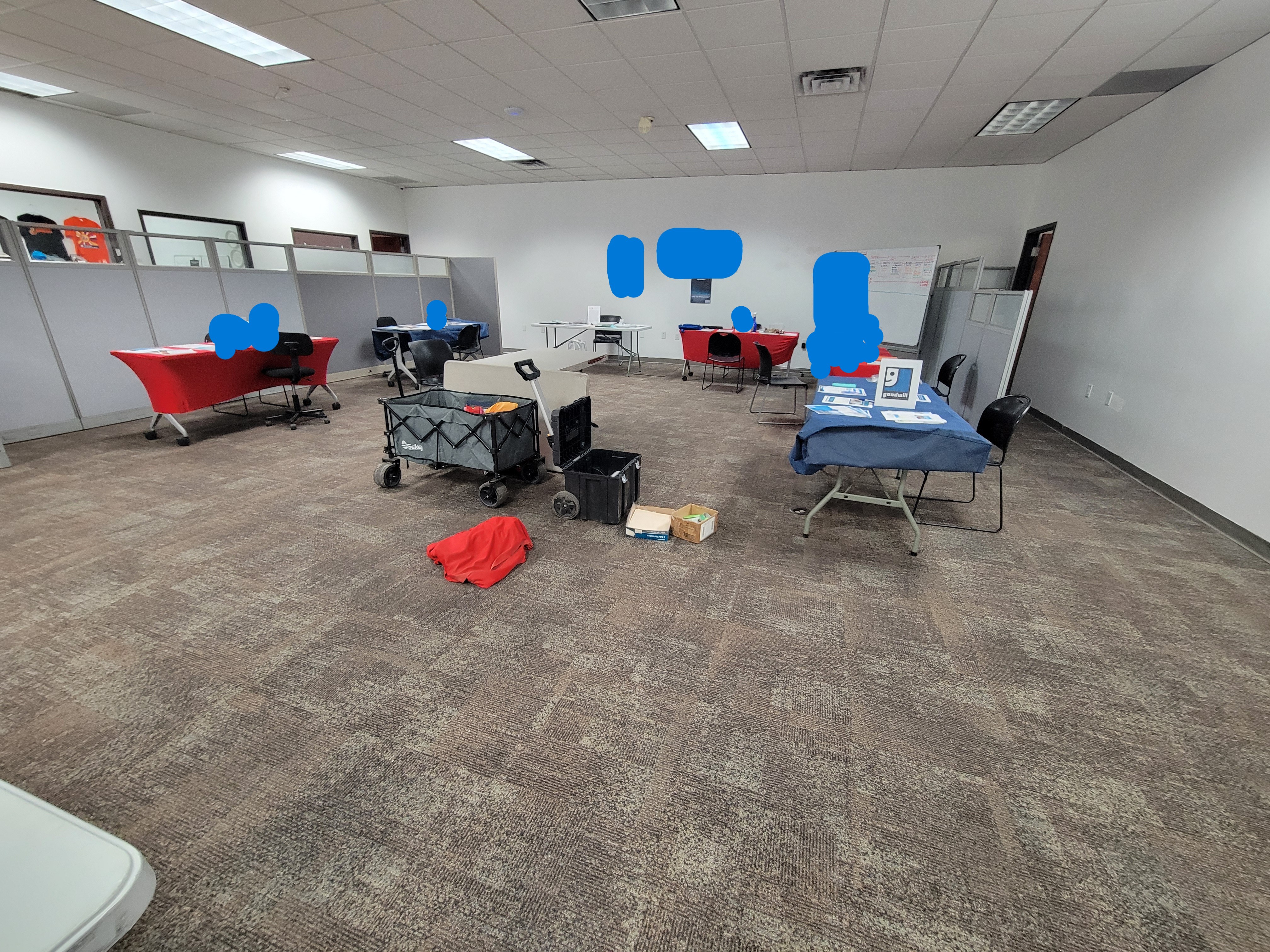 Office space with tables for different agencies lined around with a wagon in the middle.